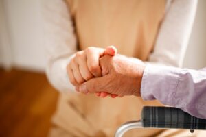 手を握る介護者と高齢者